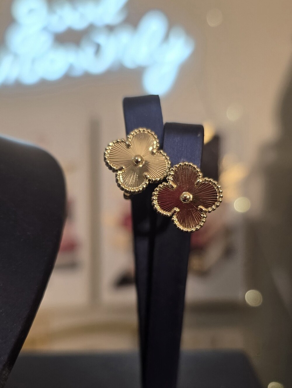 Gold Flower Stud Earrings on Black Display